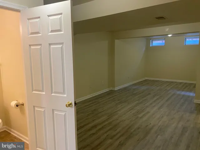 a view of a backyard with wooden fence and a bench