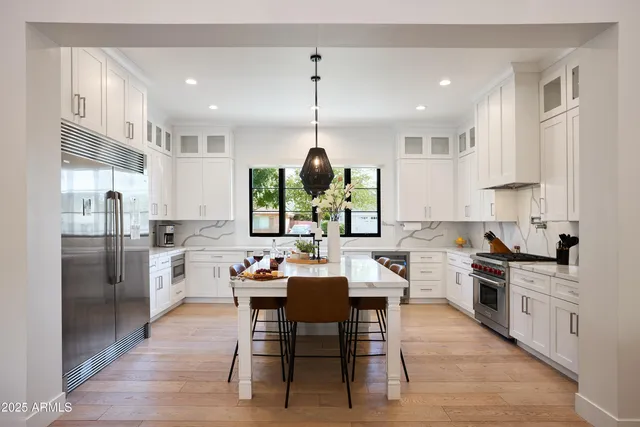 a kitchen with a dining table chairs and white cabinets