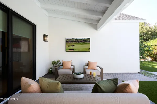 a living room with furniture kitchen view and a chandelier