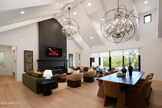 a living room with furniture a chandelier and a fireplace