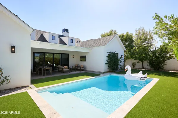 a view of a dining room with furniture one side kitchen view and wooden floor