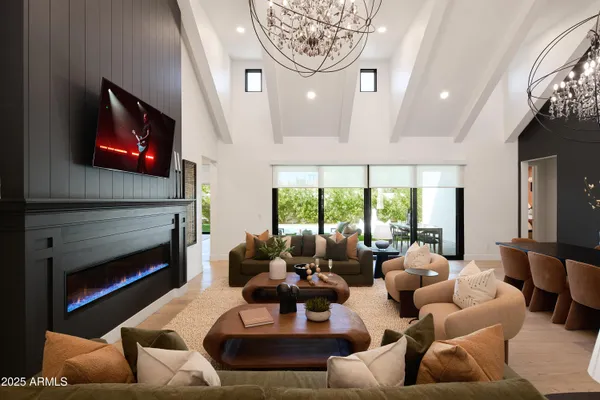 a living room with furniture a chandelier and a flat screen tv