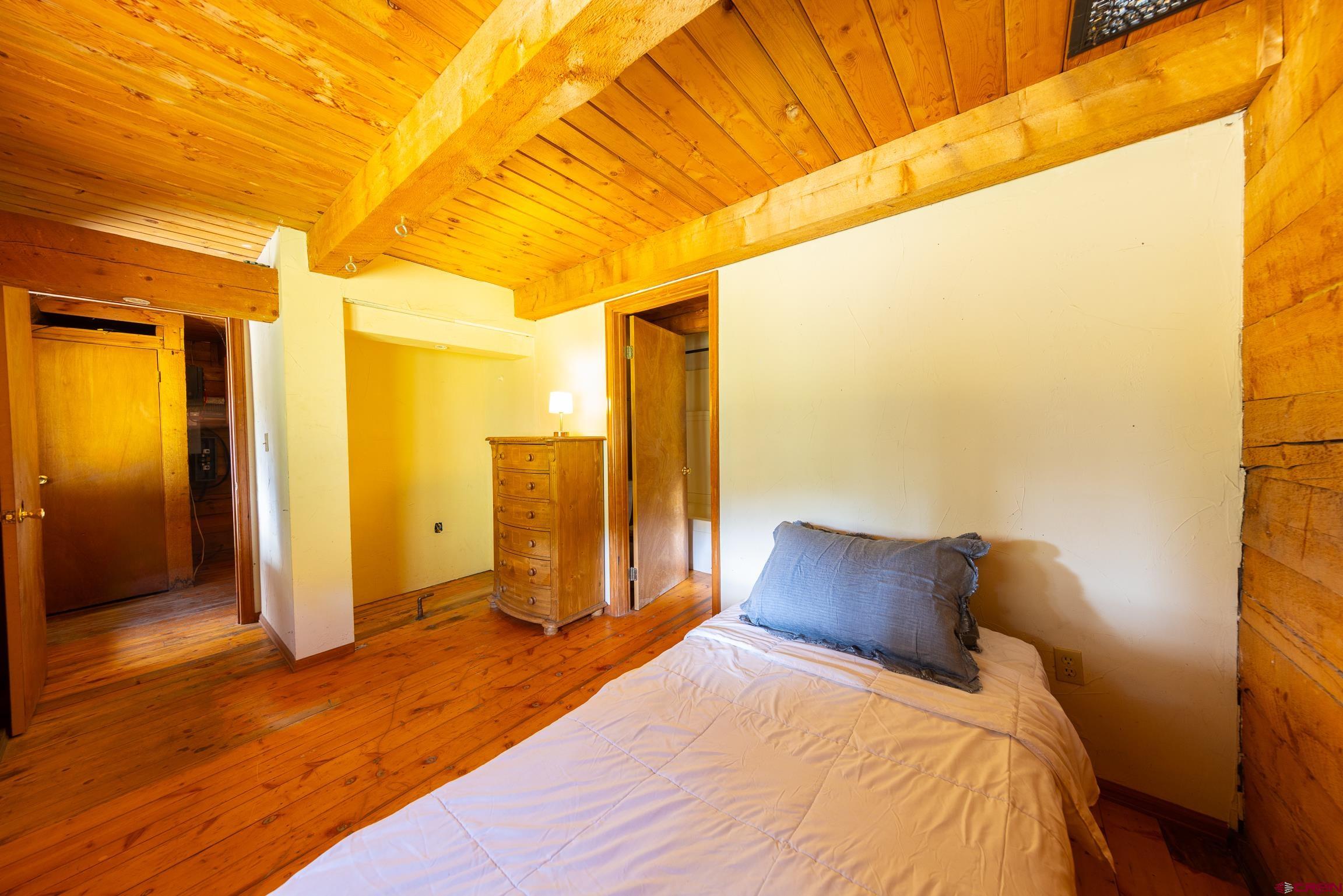 824 County Road Crested Butte, CO 81224 - Photo 28 of 39 a bedroom with a bed and wooden floor