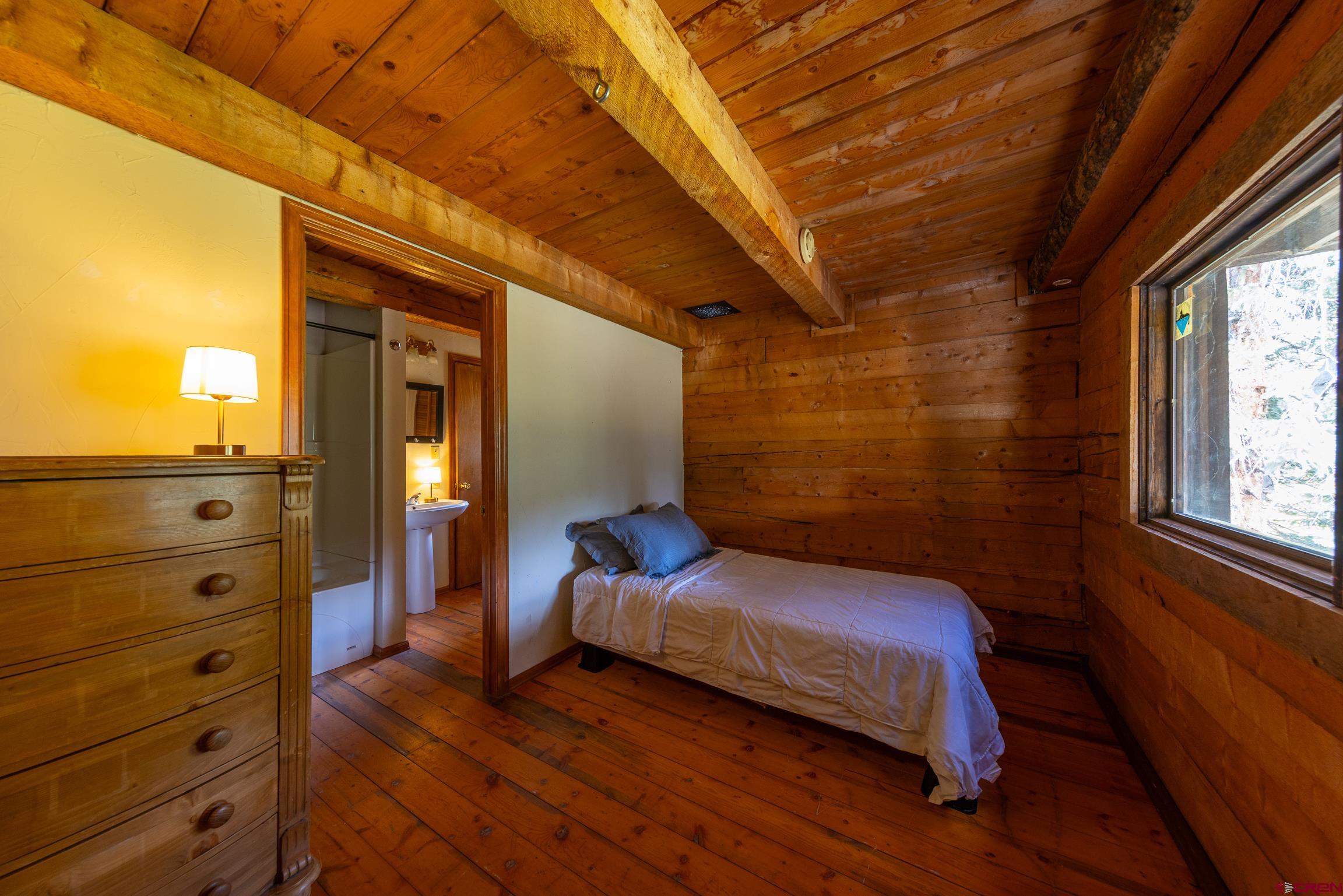 824 County Road Crested Butte, CO 81224 - Photo 29 of 39 a bedroom with a bed and a dresser next to a window