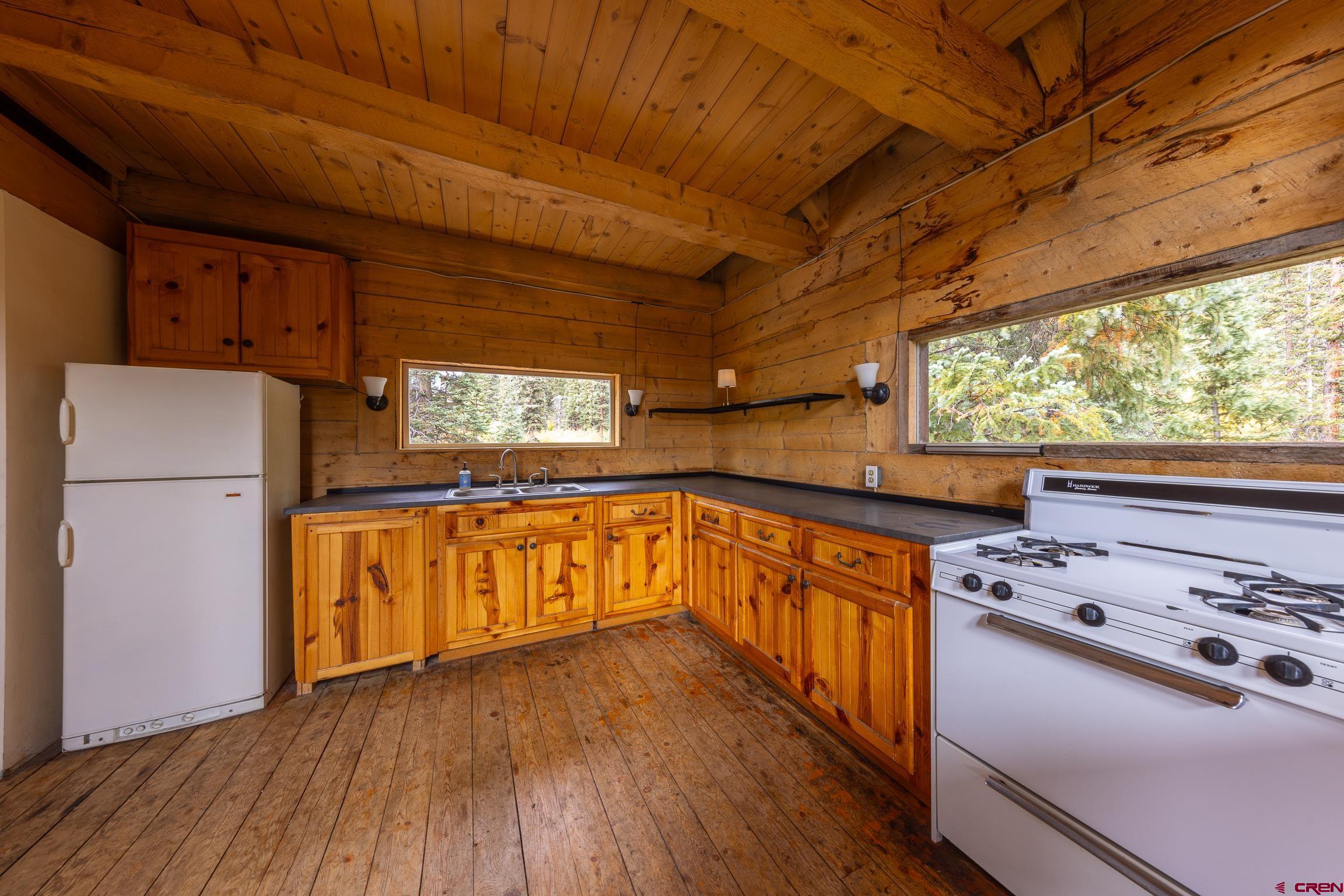 824 County Road Crested Butte, CO 81224 - Photo 7 of 39 a kitchen with stove a refrigerator and wooden floor