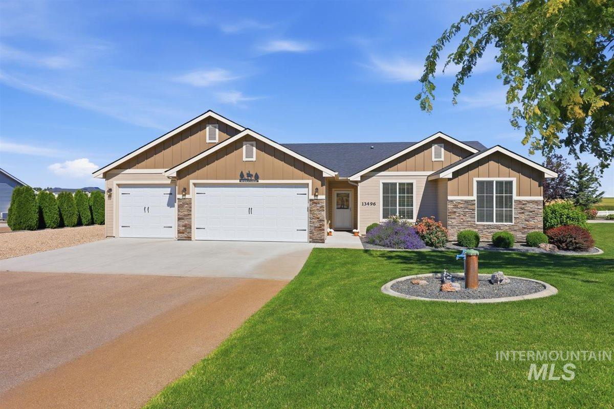 13496 Hockberger Ranch Road Caldwell, ID 83607 - Photo 2 of 40 Craftsman-style exterior featuring a stone and siding facade, two-car garage, concrete driveway, and established landscaping