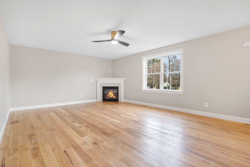 13 Main Street, Unit 13 Newbury, MA 01922 - Photo 13 of 36 an empty room with wooden floor ceiling fan and windows
