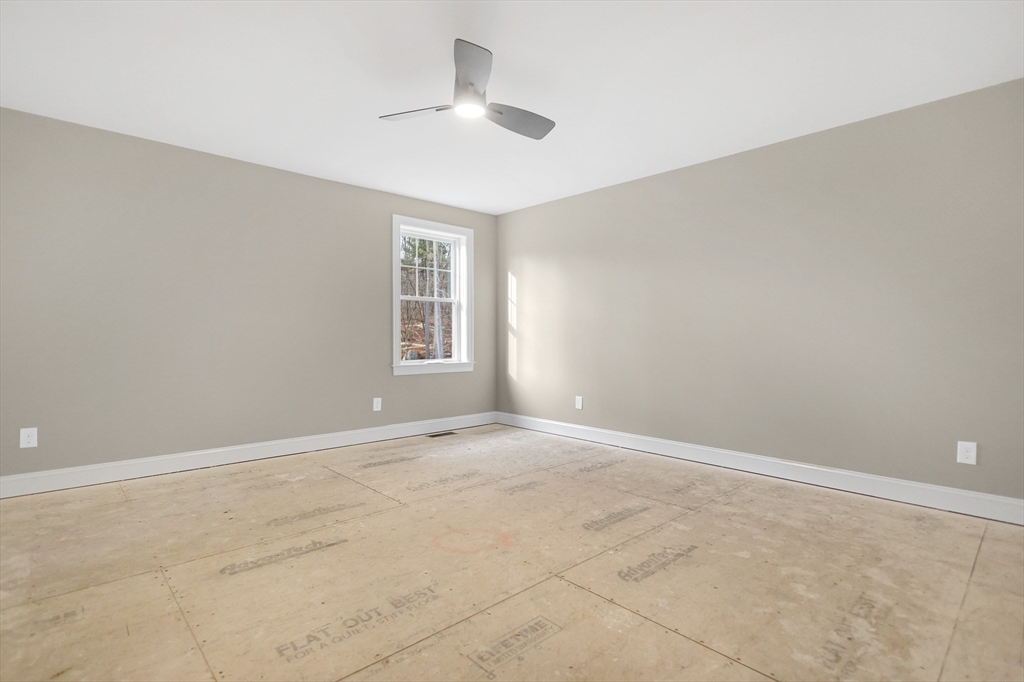 13 Main Street, Unit 13 Newbury, MA 01922 - Photo 23 of 36 an empty room with windows and ceiling fan