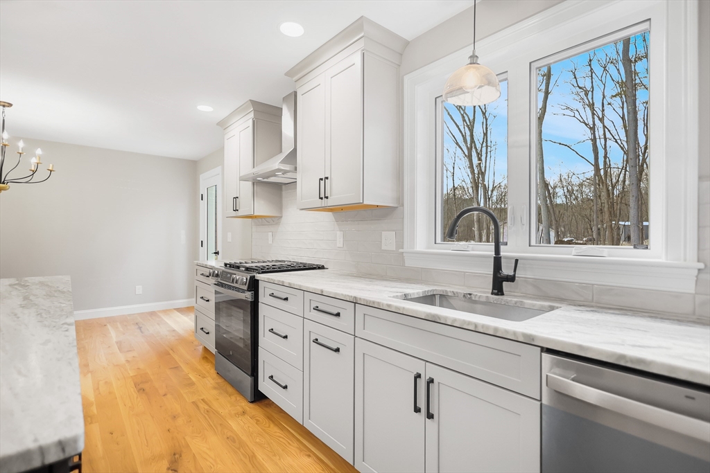 13 Main Street, Unit 13 Newbury, MA 01922 - Photo 7 of 36 a kitchen with a sink stove and cabinets