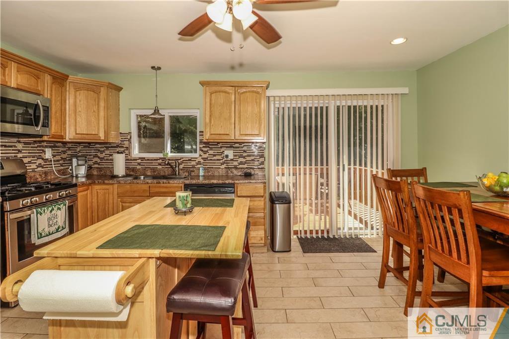 11 Brookside Road Edison, NJ 08817 - Photo 8 of 26 a kitchen with stainless steel appliances granite countertop a sink and a microwave