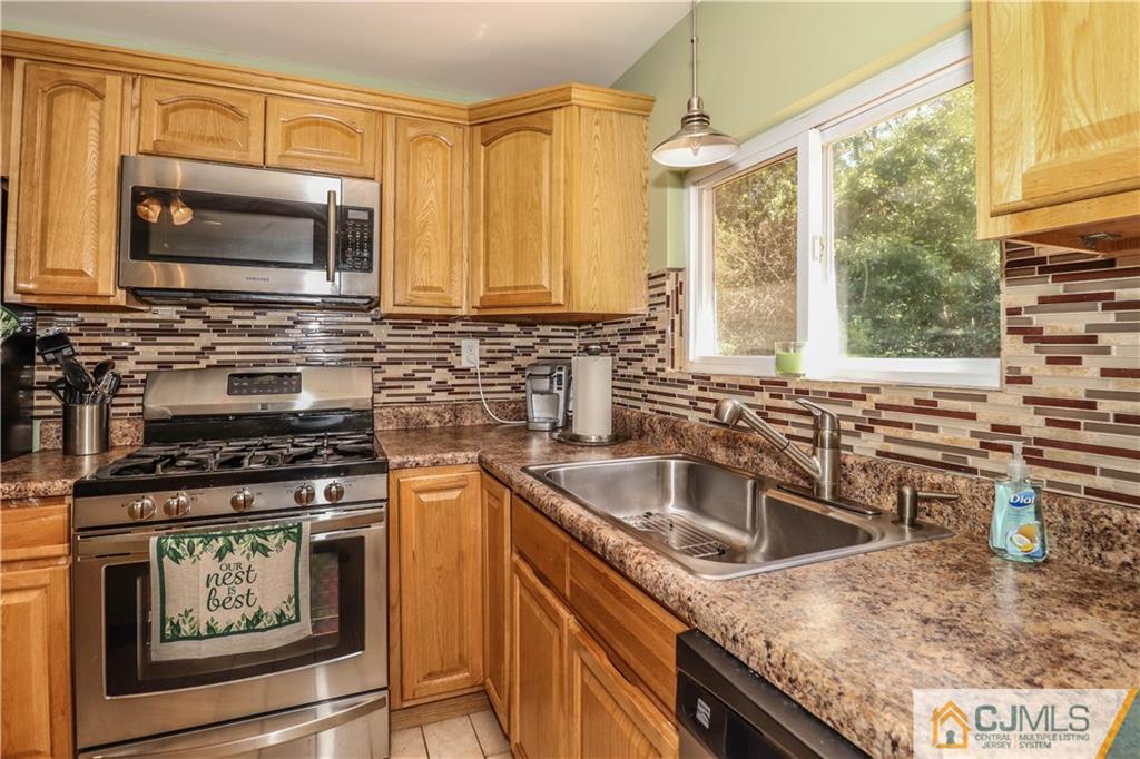 11 Brookside Road Edison, NJ 08817 - Photo 10 of 26 a kitchen with stainless steel appliances granite countertop a sink stove and microwave