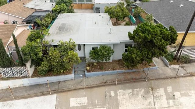 an aerial view of a house with a yard and large trees