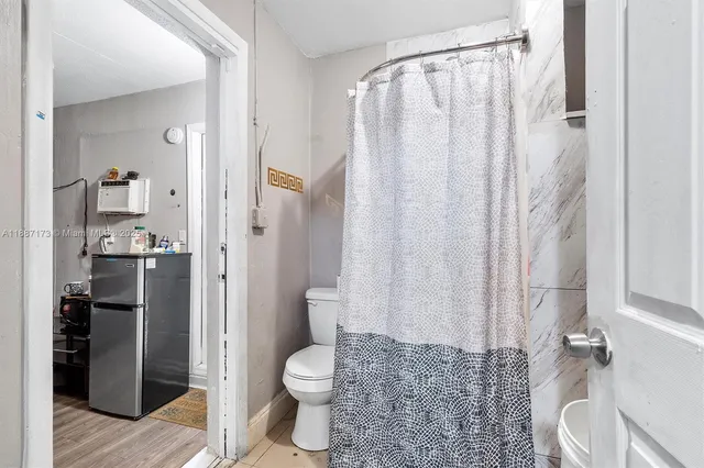 a bathroom with a toilet a sink and shower curtain
