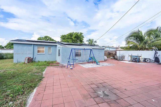 a front view of house with yard and trees around