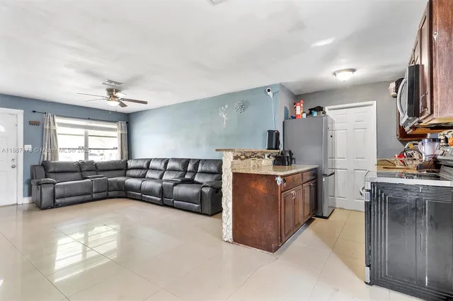 a living room with furniture and a kitchen