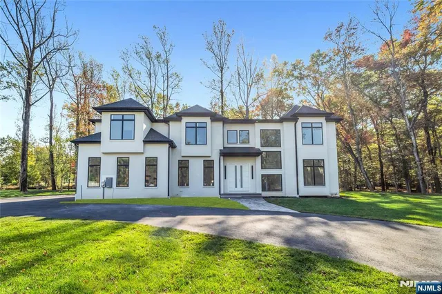 a front view of a house with yard and green space
