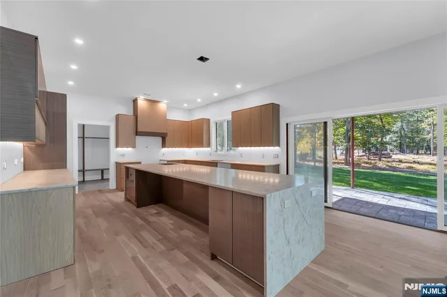 a large kitchen with kitchen island a large counter top space a sink stainless steel appliances and cabinets