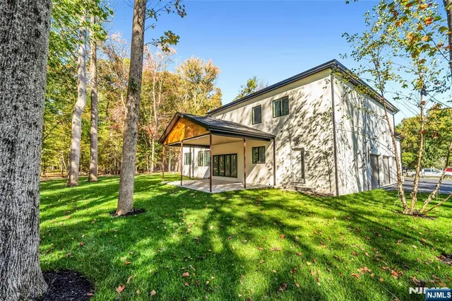a view of a house with a big yard and large trees