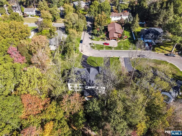 an aerial view of residential houses with outdoor space and trees