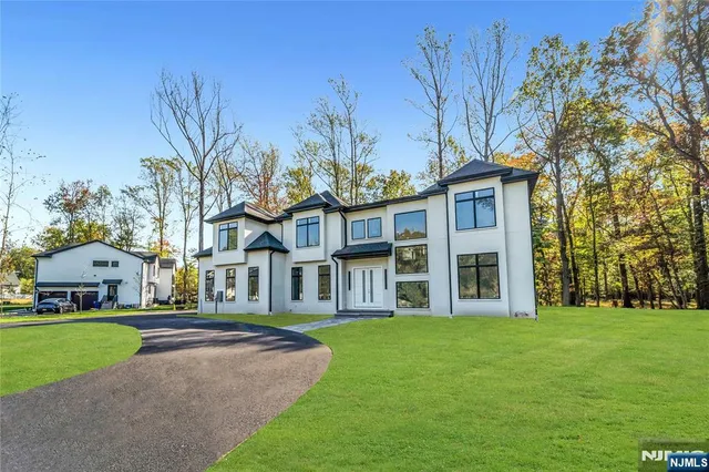 a front view of a house with a garden and tree