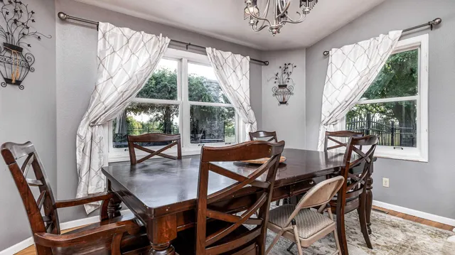 a view of a dining room with furniture large windows and wooden floor