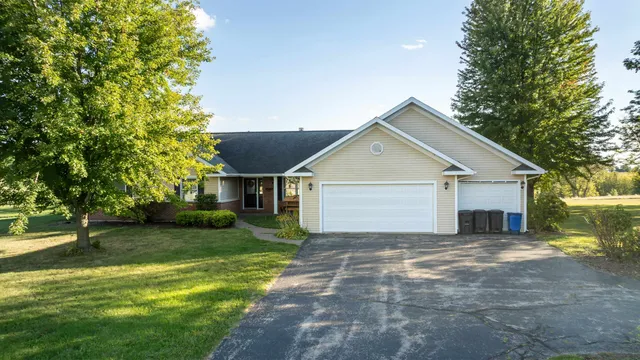 a view of a house with a yard and large tree