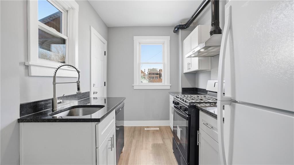 613 Paulson Avenue Pittsburgh, PA 15206 - Photo 14 of 32 a kitchen with granite countertop a sink stove and cabinets
