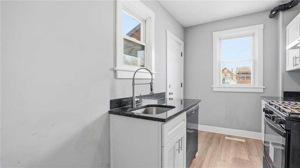 613 Paulson Avenue Pittsburgh, PA 15206 - Photo 16 of 32 a bathroom with a granite countertop sink and a window