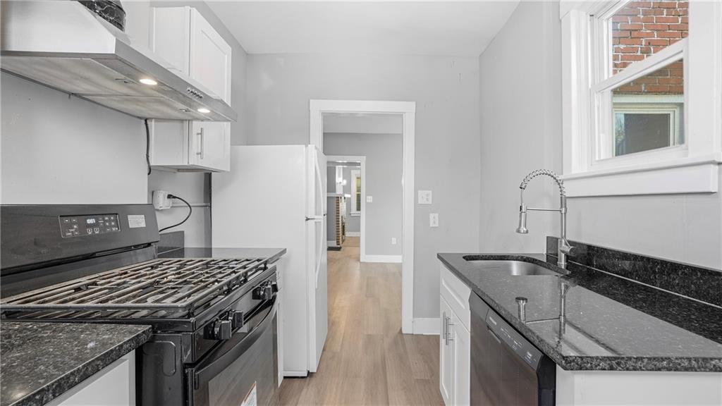 613 Paulson Avenue Pittsburgh, PA 15206 - Photo 17 of 32 a kitchen with granite countertop a sink stove and cabinets