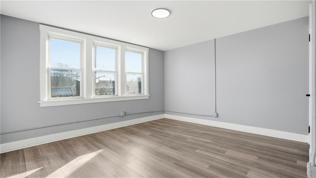 613 Paulson Avenue Pittsburgh, PA 15206 - Photo 20 of 32 a view of an empty room with wooden floor and a window