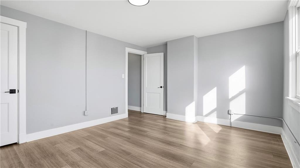 613 Paulson Avenue Pittsburgh, PA 15206 - Photo 22 of 32 a view of an empty room with wooden floor and a window