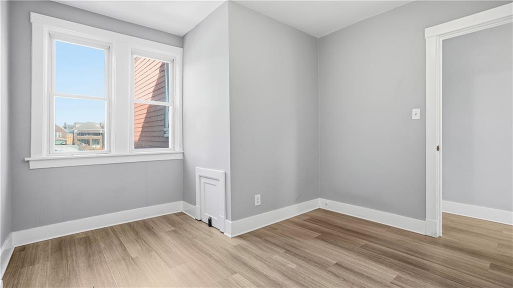 613 Paulson Avenue Pittsburgh, PA 15206 - Photo 24 of 32 an empty room with wooden floor and windows