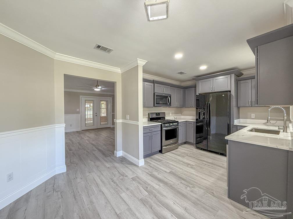 4412 Copperwood Place Pace, FL 32571 - Photo 12 of 32 a kitchen with stainless steel appliances kitchen island granite countertop a refrigerator and a stove top oven