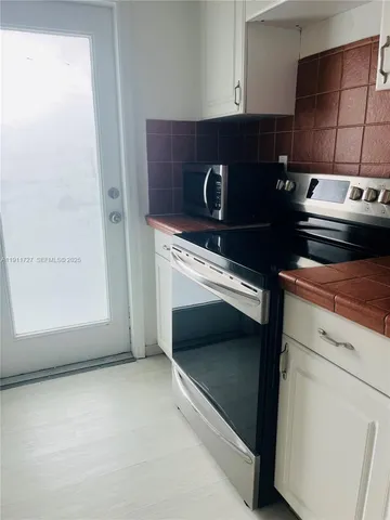 a metallic refrigerator freezer sitting in a kitchen
