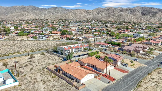 an aerial view of residential houses with outdoor space and trees