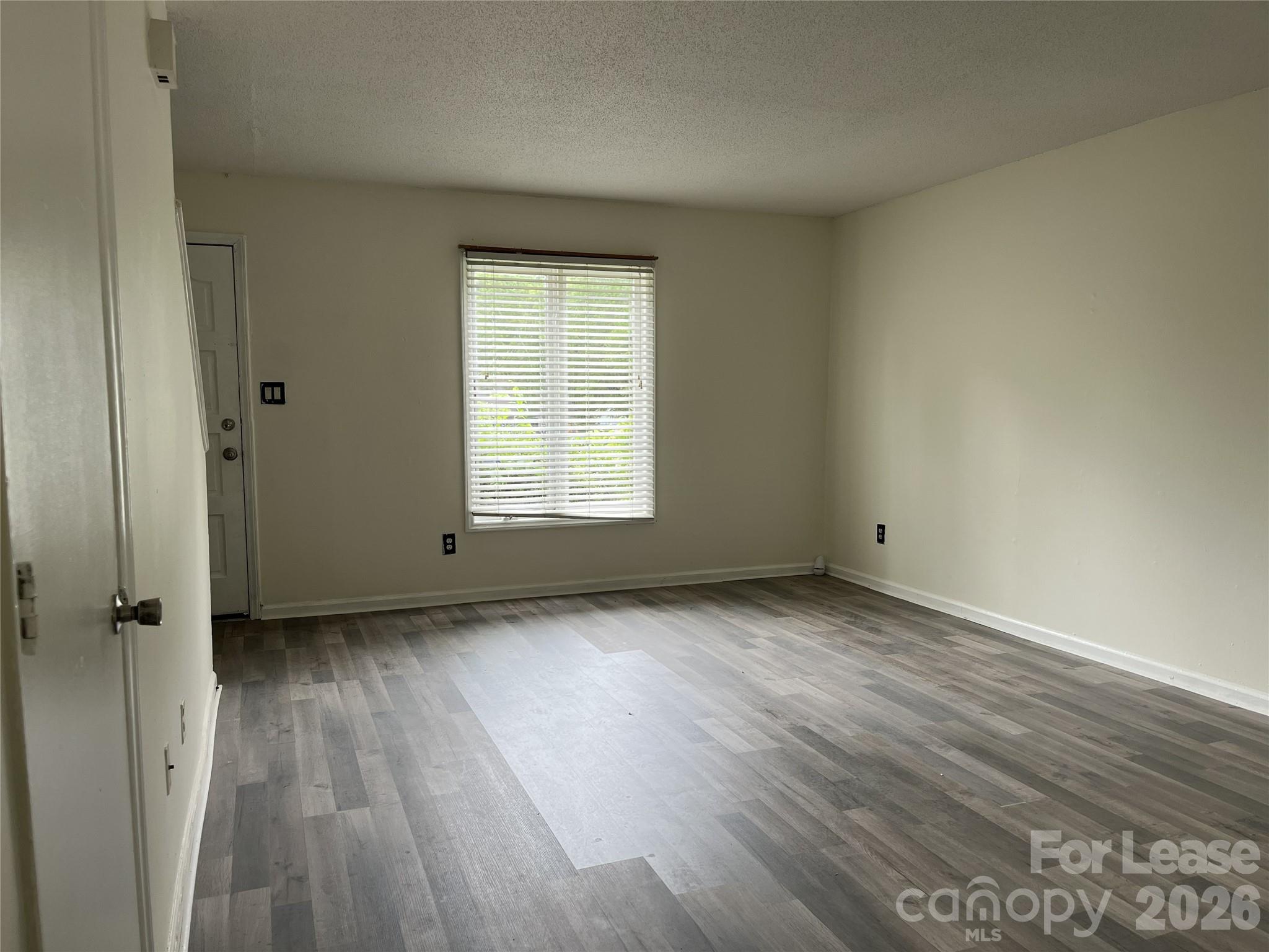 1911 Smoke Ridge Court, Unit 5 Charlotte, NC 28210 - Photo 3 of 16 an empty room with wooden floor and a window
