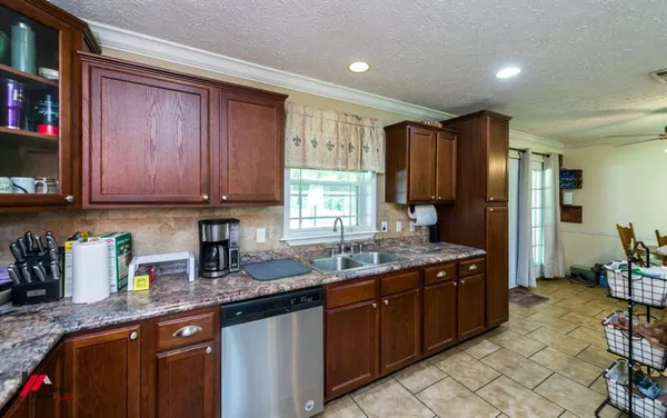 a kitchen with stainless steel appliances granite countertop wooden cabinets a sink and dishwasher