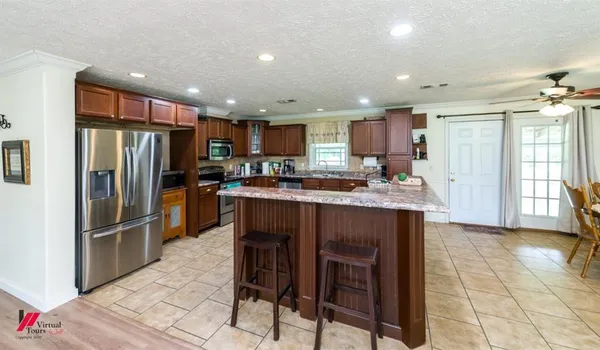 a kitchen with stainless steel appliances granite countertop a refrigerator and a stove top oven