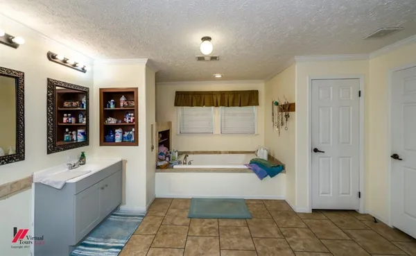 a bathroom with a tub a sink and a mirror