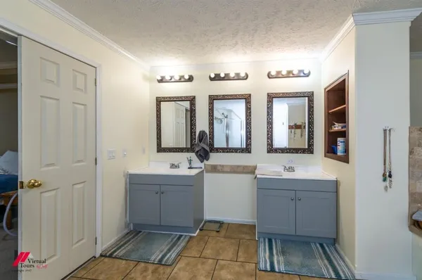 a spacious bathroom with a double vanity sink a mirror and a shower
