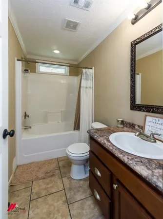 a bathroom with a granite countertop sink toilet mirror and bathtub