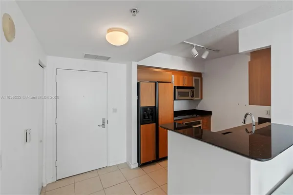 a kitchen with stainless steel appliances granite countertop a refrigerator and a sink