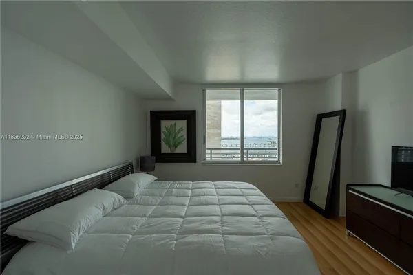 a bedroom with a bed and a large window