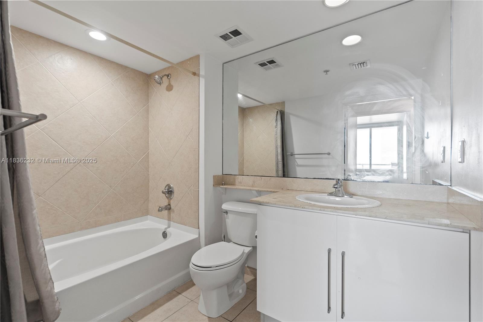 335 South Biscayne Boulevard, Unit 3410 Miami, FL 33131 - Photo 35 of 51 a bathroom with a granite countertop sink toilet a large mirror a bathtub and shower