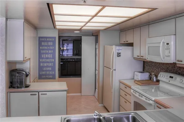 a kitchen with a refrigerator sink and cabinets