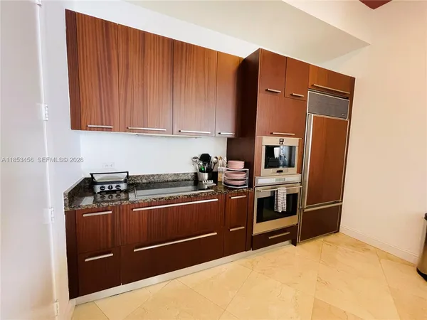 a kitchen with stainless steel appliances granite countertop a refrigerator and a stove top oven