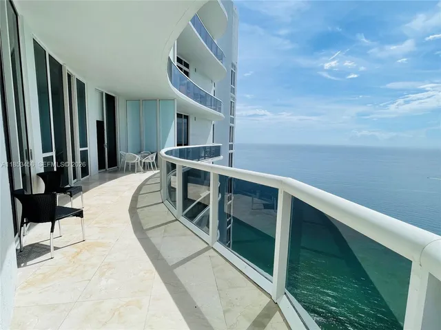 a balcony with table and chairs