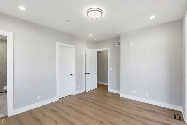 a kitchen with stainless steel appliances granite countertop a refrigerator a sink dishwasher a stove and white cabinets with wooden floor