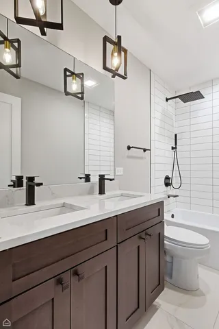 a bathroom with a sink a toilet a mirror and shower