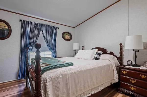 a bedroom with bed and a lamp with wooden floor